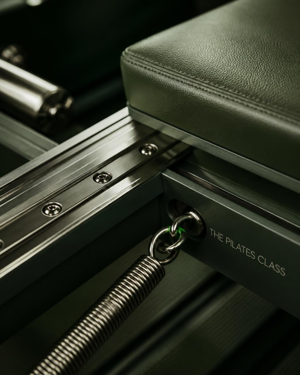 Close-up of a precision-engineered reformer carriage and rail in a professional studio